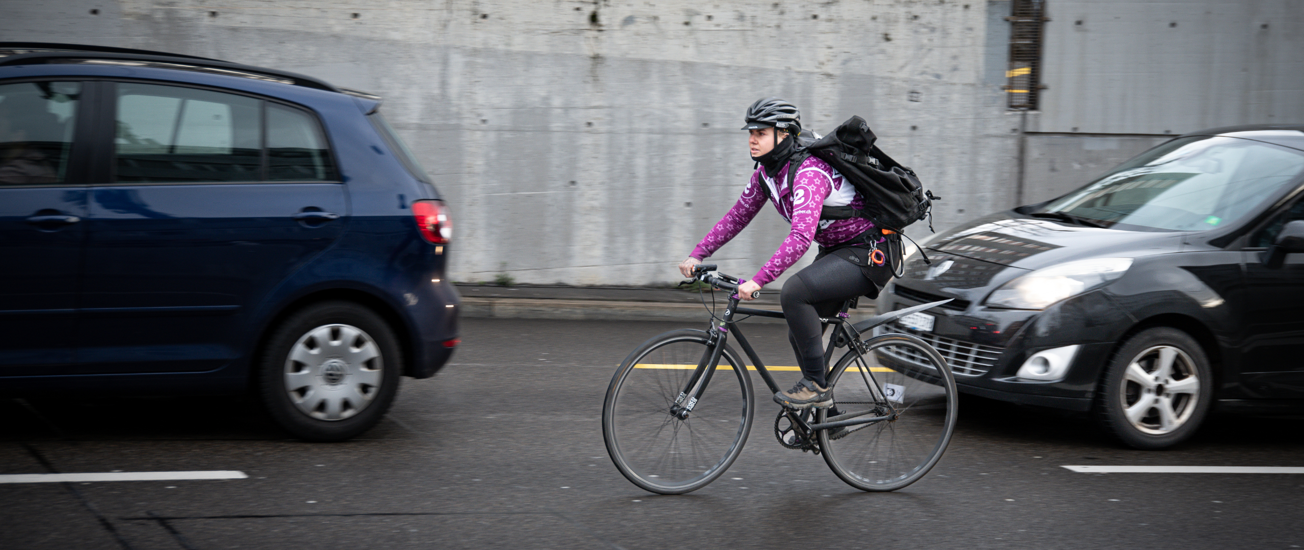Kurierende fährt an Autos vorbei