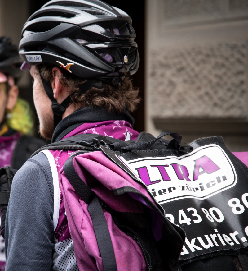Kurierender mit Helm trägt einen grossen Rucksack