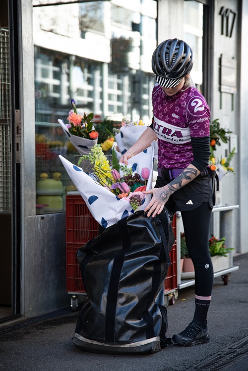 Kurierende packt Blumen in Rucksack